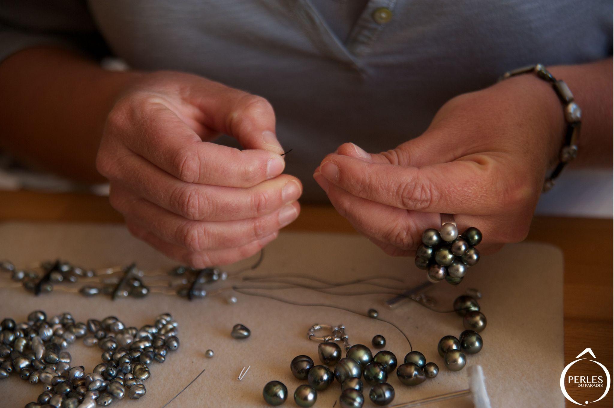 Mains ed Nathalie Le Gloahec entrain de monter un collier de perles de culture de Tahiti